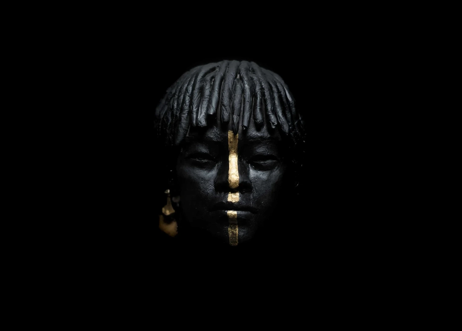 Sculpture de la série Terres Ethniques, visage marqué d'une ligne de feuille d'or